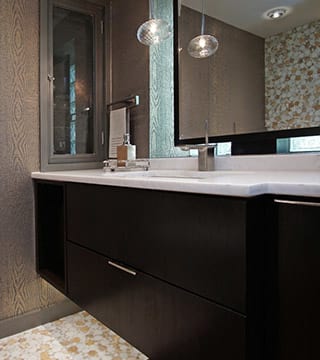 Lake Forest bathroom design with dark brown finish, accent wallpaper, two tone floor tile